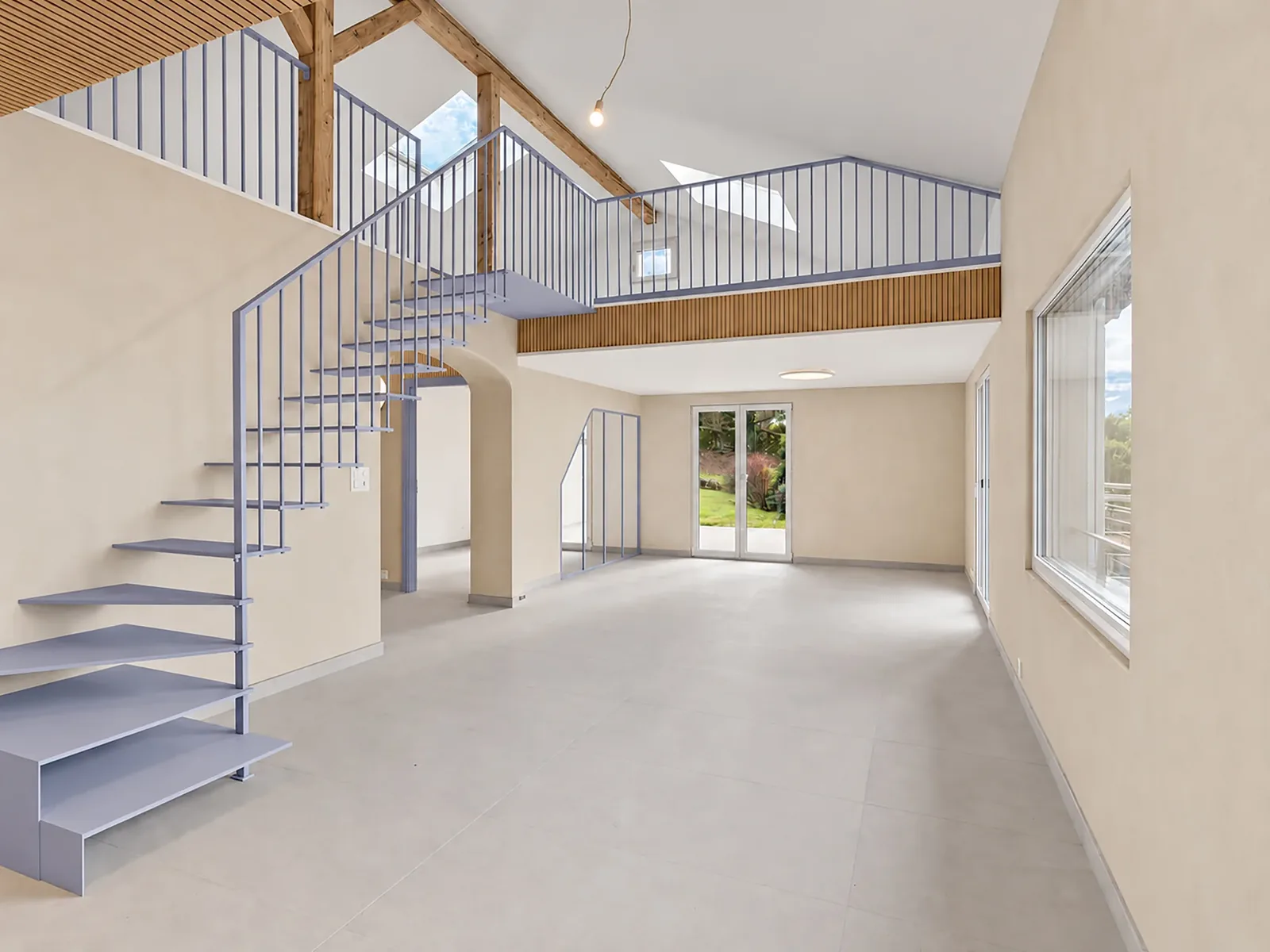 Grand volume sous charpente avec mezzanine et escalier bleu — Deux escaliers au cœur d'un projet, Villeneuve, canton de Vaud